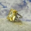 square cut chartreuse ring on a rock with a sky background