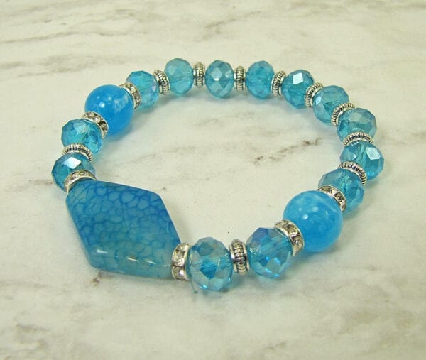 bracelet with blue beads and large pendant on a marble surface