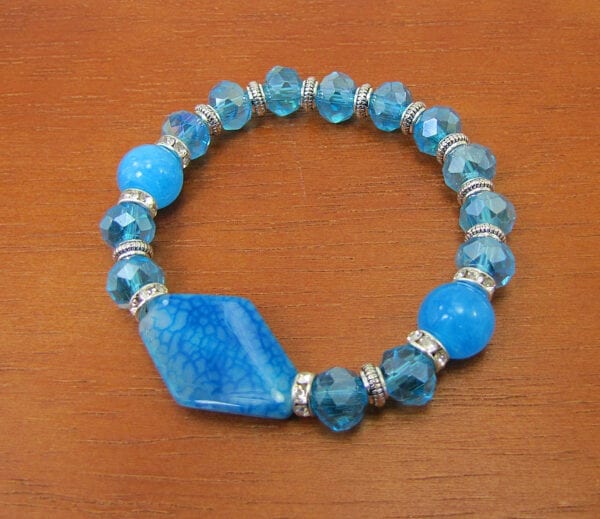 bracelet with blue beads and large pendant on a wooden surface