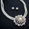 necklace and earrings with pearls arranged in floral patterns