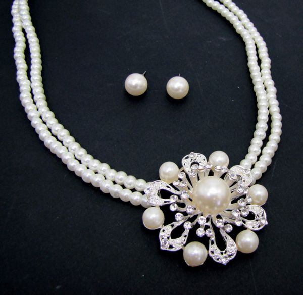 necklace and earrings with pearls arranged in floral patterns