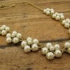 necklace with pearls arranged like flowers on a wooden surface