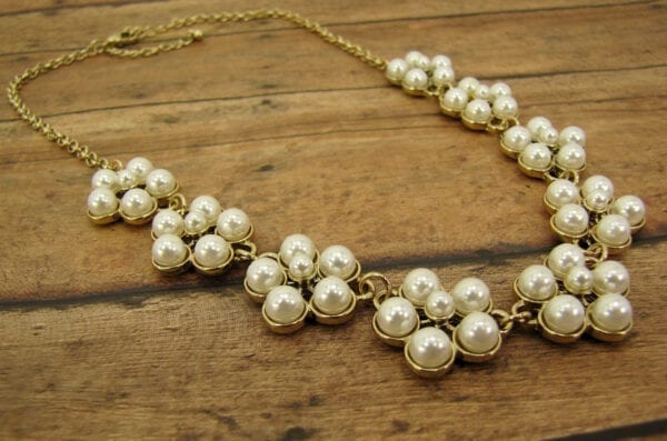 necklace with pearls arranged like flowers on a wooden surface