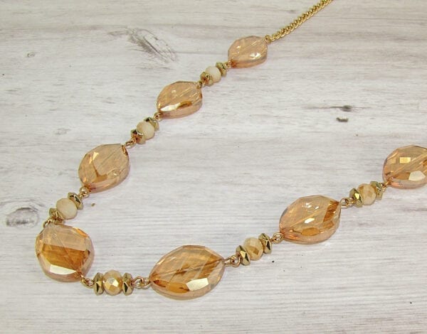 necklace with large orange crystals on a wooden surface
