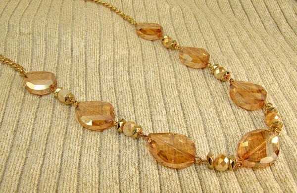 necklace with large orange crystals on a corduroy surface