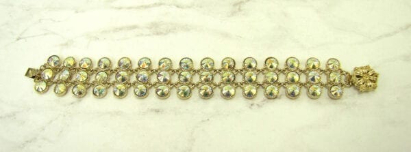 bracelet with rows of iridescent crystals laid horizontally on a marble surface