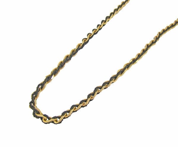 segment of a twisted necklace with gold chain and black pearls