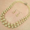 pearl earrings and necklace on a light pink surface