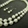 pearl earrings and necklace on black velvet surface