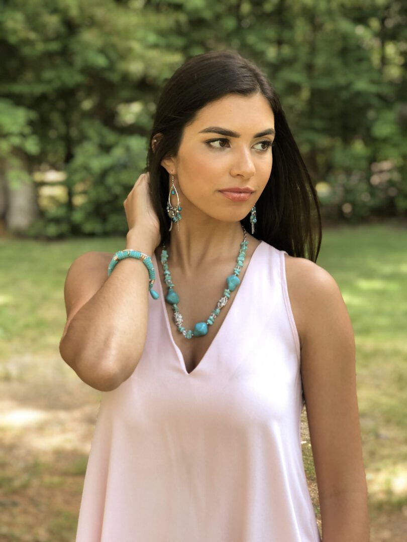 A woman in white tops wearing a necklace