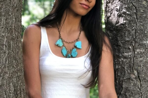 girl wearing necklace with large, flat turquoise stones