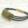bracelet with large green rectangular pendant on a marble surface
