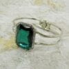 square cut emerald bangle on a concrete surface