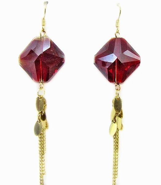 close up of earrings with red gem and tassel