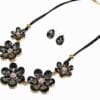 necklace and earrings with dark gemstones arranged in flowers
