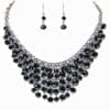 layered necklace and earrings with dark circular crystals