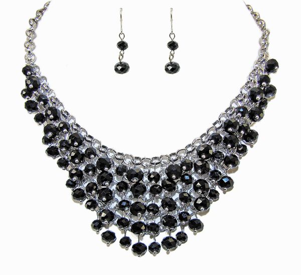 layered necklace and earrings with dark circular crystals