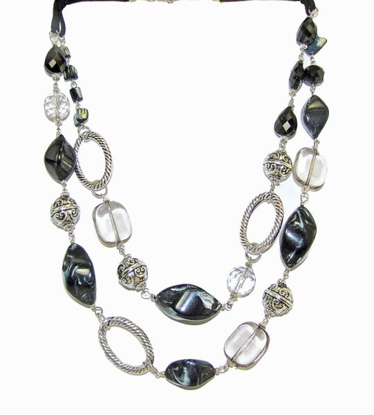 layered necklace with silver beads and dark gems