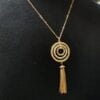necklace with concentric pendants and brown tassel on a black mannequin