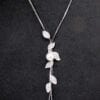 necklace with cascading leaf design and pearl and silver gems on a black velvet surface