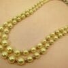 pearl necklace with two layers on a light pink surface