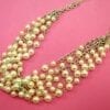 pearl necklace with silver chains on a pink solid surface