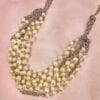 pearl necklace with silver chains on a pink silk surface