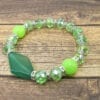 bracelet with jade beads and large jade pendant on a wooden surface