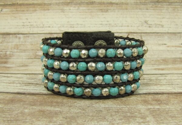 black bracelet with silver and sky blue beads on a wooden surface