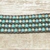 black bracelet with silver and sky blue beads laid horizontally