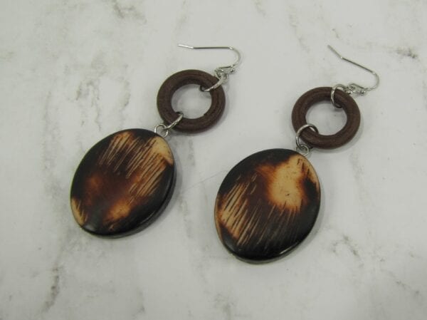 earrings with brown circle ring and oval pendant on a marble surface