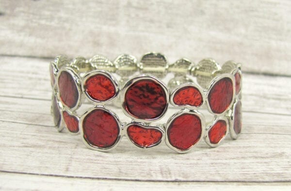 bracelet with deep red crystal inset on a wooden surface