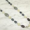 necklace with black, white, and gray stones on marble surface