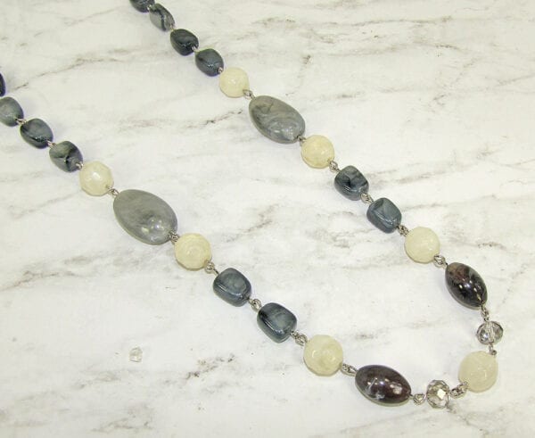 necklace with black, white, and gray stones on marble surface