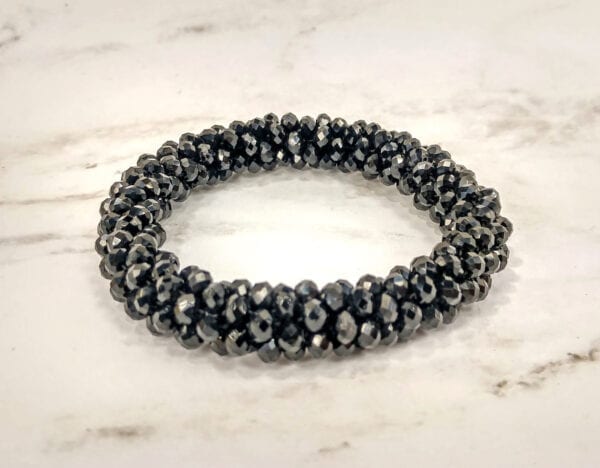 bracelet with clusters of black crystals on a marble surface