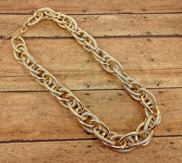 golden necklace with layers of gold chain links on a wooden surface