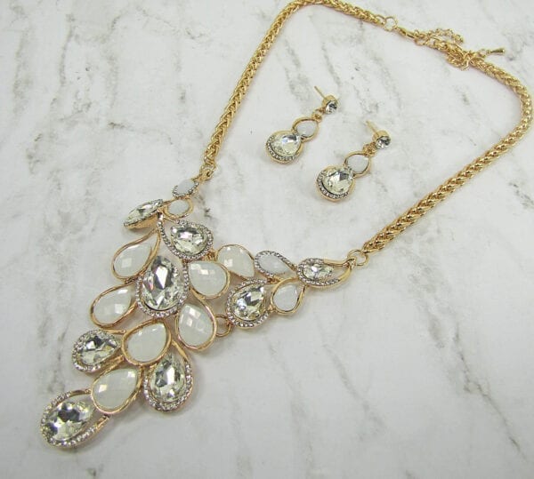 necklace and earrings with pearl and diamond crystals arranged like vines on marble surface
