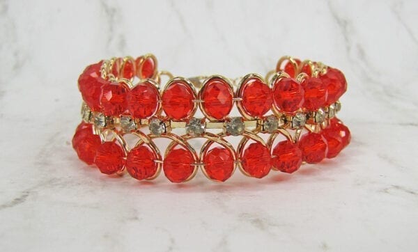 bangle with rows of bright red stones on a marble surface