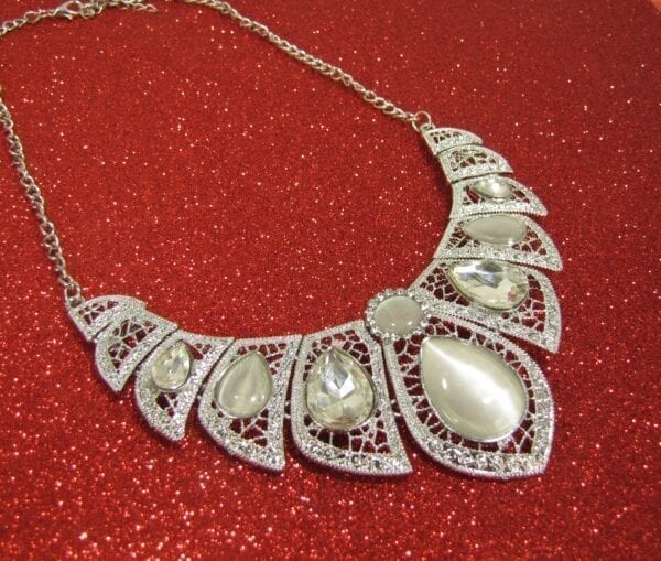 necklace and earrings with pearl and diamond gems on a glittery red surface