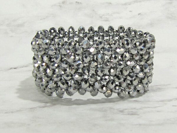 bracelet with rows of silvery beads on a marble surface