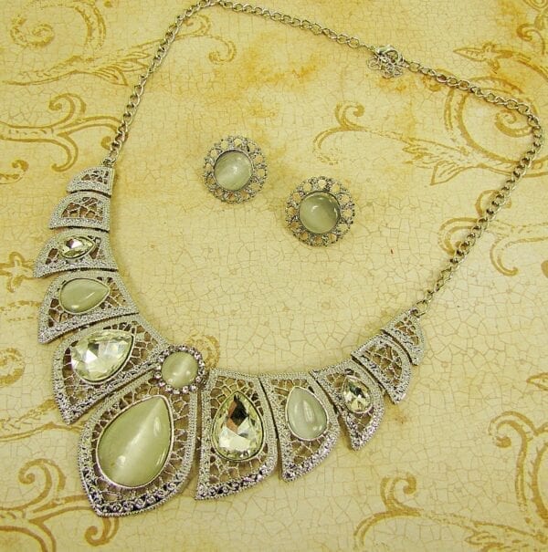 necklace and earrings with pearl and diamond gems on a yellow cloth surface