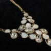 necklace with pearl and diamond crystals arranged like vines on a black velvet surface
