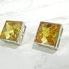 square-cut topaz earrings on marble surface