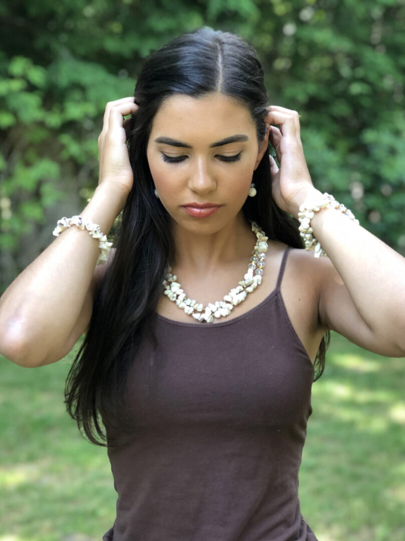 A woman in brown tops wearing a necklace