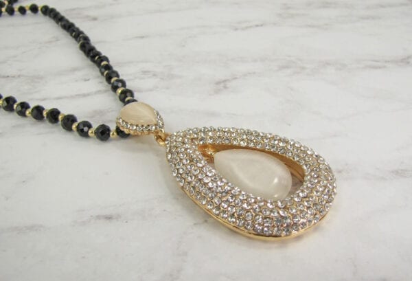 necklace pendant with teardrop pearl design on marble surface