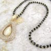 necklace with teardrop pearl design on marble surface