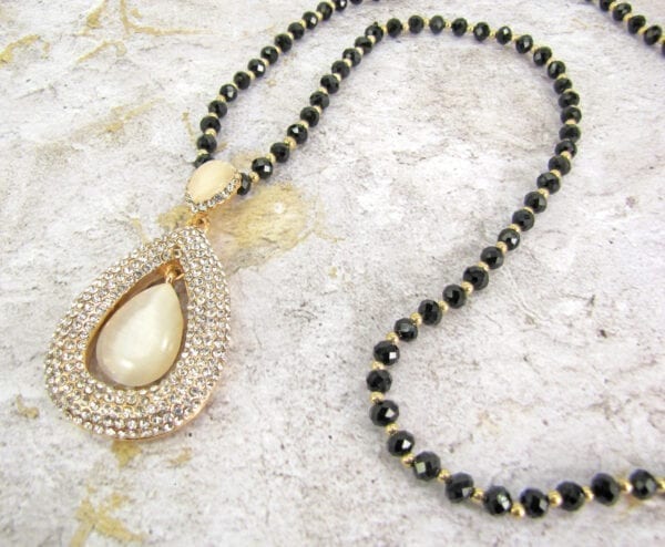 necklace with teardrop pearl design on marble surface
