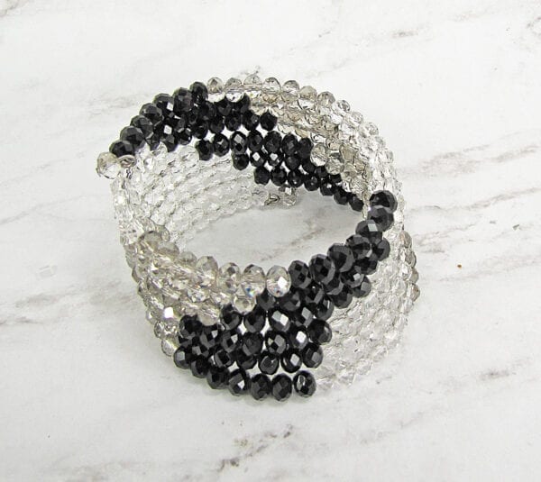 bracelet with black beads and white crystals on marble surface