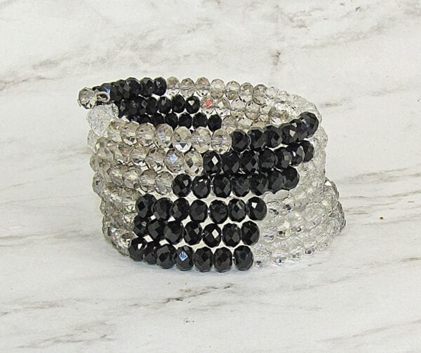bracelet with black beads and white beads on marble surface