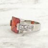 side view of a ring with square-cut garnet gem on a marble surface